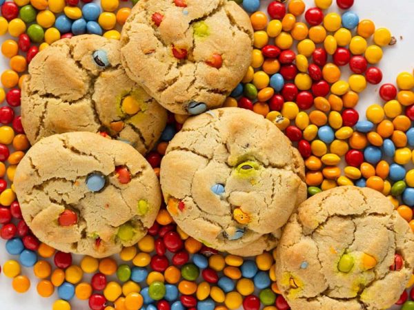Colorful candy M&M cookies on a rainbow bed of coated chocolates.